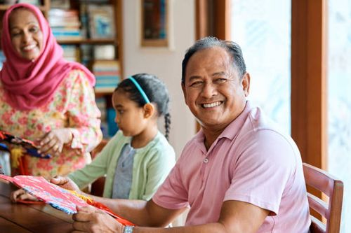 smiling senior man making wau bulan with family - wau malaysia stock pictures, royalty-free photos & images