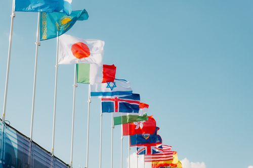 Free A row of international flags waving under a clear blue sky in Paris, France. Stock Photo