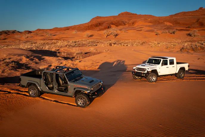 Jeep Wrangler and Jeep Gladiator driving through desert terrain, showcasing off-road performance