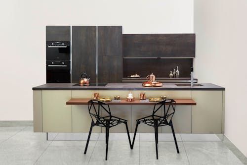 Free Elegant modern kitchen featuring copper accents and minimalist design. Stock Photo