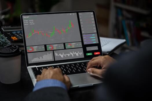Businessman trader looking on laptop with graphs analysis candle line report stock market diagram profit. photo