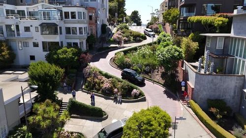 Aerial view of Lombard Street’s famous crooked block in San Francisco, showcasing its eight sharp hairpin turns winding steeply through Russian Hill, a top tourist attraction.