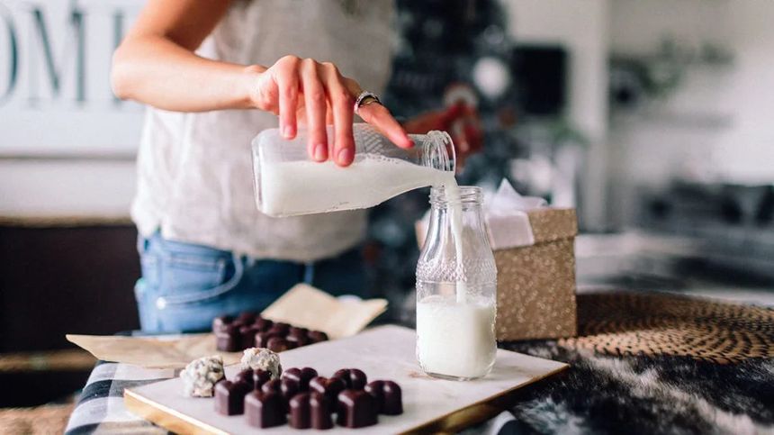 a woman pouring milk as she likes the benefits of it