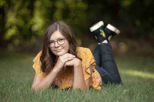 A cute girl pose with a girl resting in the grass