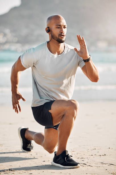 Shot of a young man doing lunges on the beach Sometimes you don’t realize your own strength lunge exercise man stock pictures, royalty-free photos & images