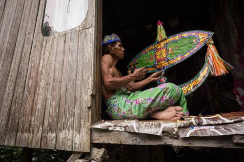 unidentified man is making the traditional moon kite or locally known as "wau bulan" - malaysia wau stock pictures, royalty-free photos & images