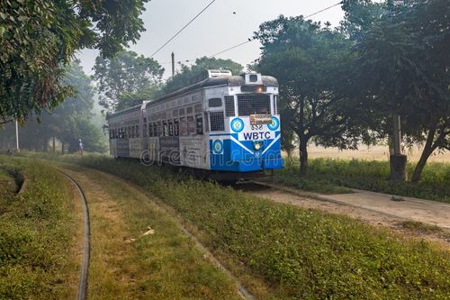 KOLKATA, INDIA - DECEMBER 12, 2016: A heritage and historic Calcutta tram moves through the Kolkata Maidan area on a foggy winter morning. Kolkata tram stock images, royalty-free photos and pictures