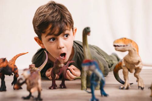 portrait of little boy playing with toy dinosaurs - dinosaur images for kids stock pictures, royalty-free photos & images
