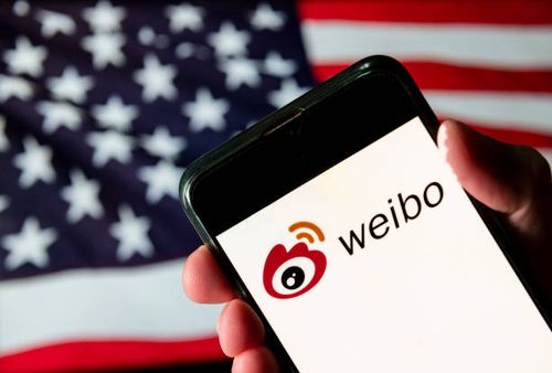 In this photo illustration the Chinese social media platform, Weibo logo is seen on an Android mobile device with United States of America flag in...