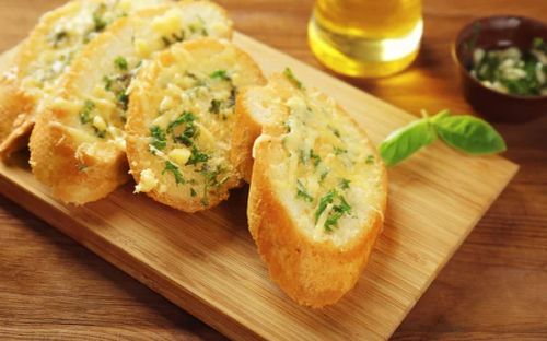 Tasty bread with garlic, cheese and herbs — Stock Photo, Image
