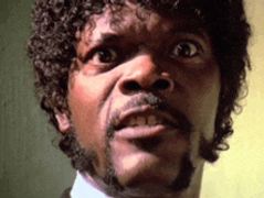 a close up of a man 's face with curly hair