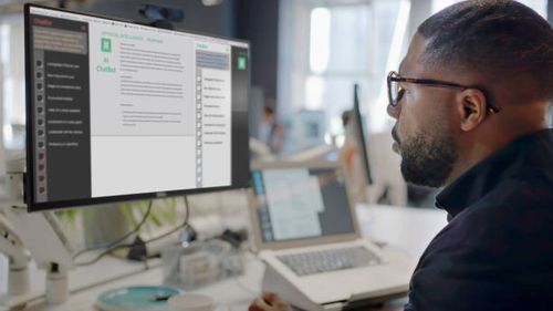 AI Chat office Stock image showing a black man’s face looking into a computer screen in an open plan working office. Type is being added to the screen by an Artificial intelligence, AI, chatbot. chat bot stock pictures, royalty-free photos & images