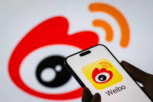 Smartphone screen displays the Weibo app logo, with the official Weibo logo in the background, on November 6, 2024 in Chongqing, China. Weibo, one of...