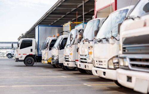 trucks parked in a distribution warehouse ready to deliver some cargo - import stock pictures, royalty-free photos & images