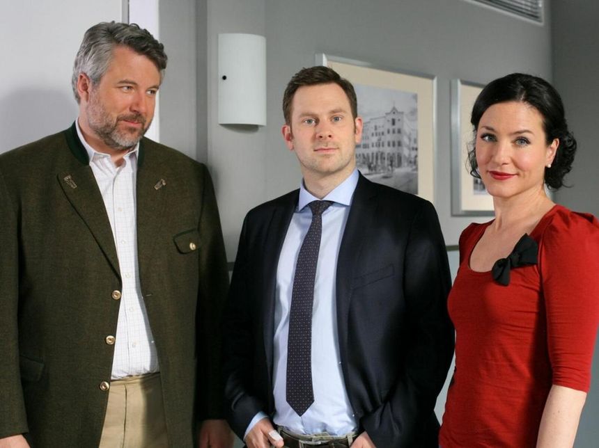 Neuzugang Sebastian König (Mark-Alexander Solf, m.) ist der Neffe von Dr. Lauser-König aus dem Innenministerium. Das sorgt vor allem bei Stadler (Dieter Fischer, l.) und Stockl (Marisa Burger, r.) für Nervosität.