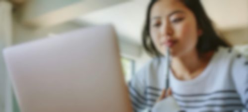 [Featured image] A learner in a striped sweater researches computer science vs. information technology majors on a laptop.