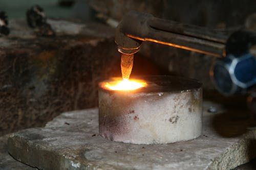 Free A close-up view of a metal smelting process using a torch, illustrating heat and sparks. Stock Photo