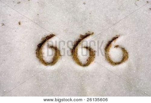 Macro of numbers 666 engraved on granite headstone