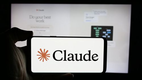 Stuttgart, Germany - 2024-10-10: Person holding cellphone with logo of AI model Claude (Anthropic PBC) on screen in front of company webpage. Focus on phone display.