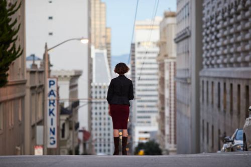 businesswoman standing on top of steep san francisco street and looking out - san francisco streets stock pictures, royalty-free photos & images
