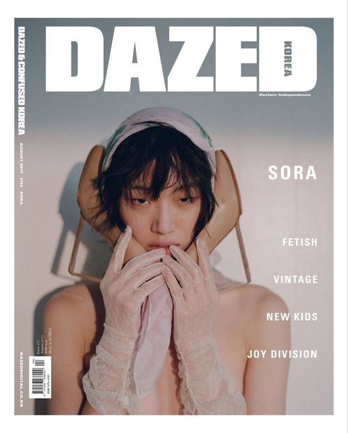 a woman covers her face with gloves on the cover of dazed magazine