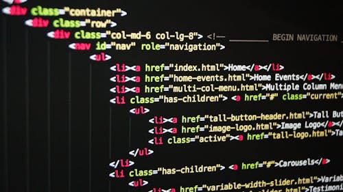 Free Close-up of vibrant HTML code displayed on a computer screen, showcasing web development and programming. Stock Photo