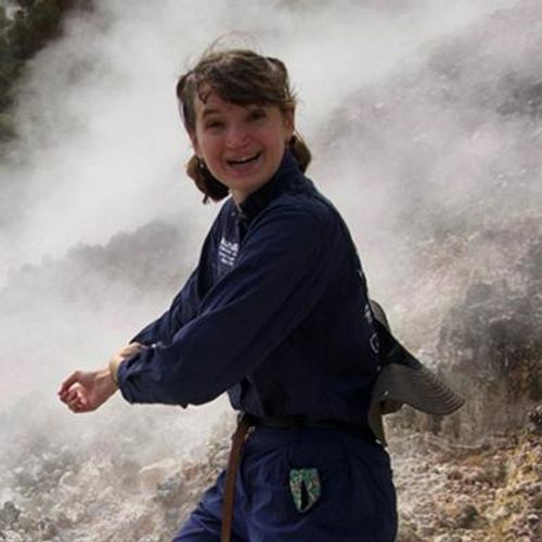 Taylor Winckle in a blue jumpsuit, walking down a hill with steam all around