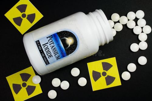 Potassium Iodide Pills Spilling from Bottle - Treatment for Radiation Exposure - Universal Radiation Symbols. Iodine stock images, royalty-free photos and pictures