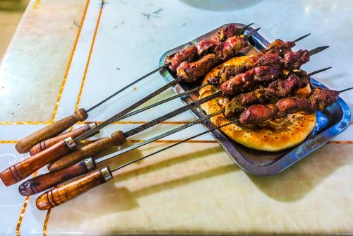 Cultural scene of Uyghur people enjoying lamb skewers