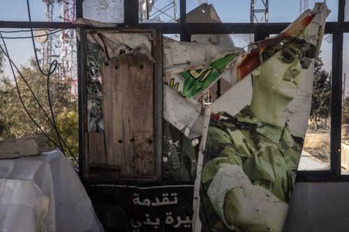Ripped poster of Bashar al-Assad is seen in the window of a lookout tower on the summit of Mount Zayn al-Abidin on December 18, 2024 at Jabal Zayn...