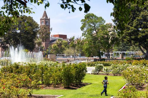 Los Angeles, CA A child runs in the grass amidst the scenic beauty of the Exposition Park Rose Garden on a warm day in Exposition Park in Los Angeles...