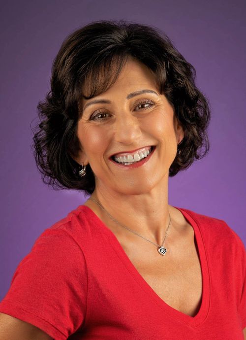 smiling woman in red shirt with purple background, karen vaisman photography