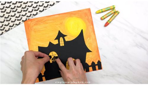 Hand gluing window of the Haunted House Craft