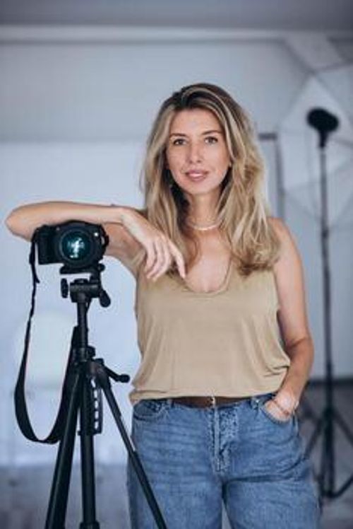 Female photographer working in a studio with professional equipment, focusing on her subject. photo