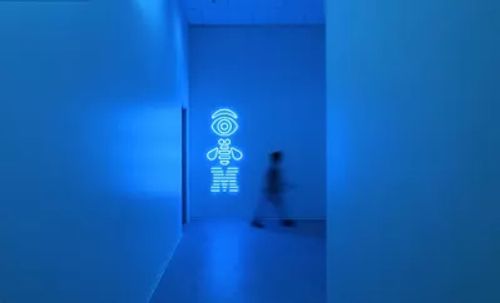 IBM 徽标墙前走过一个模糊人影