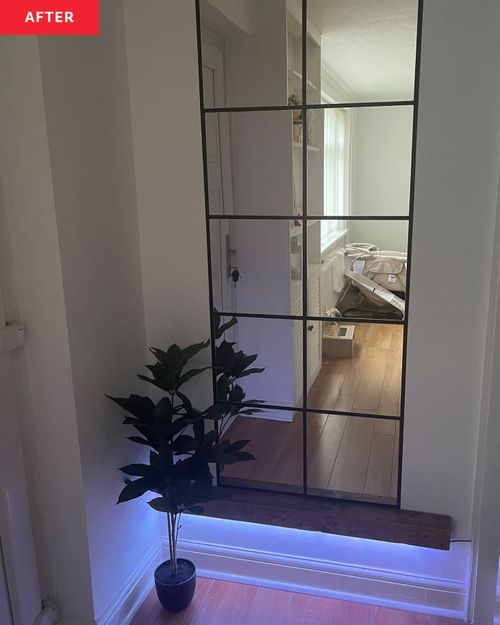 Part of white wall after installing multiple IKEA mirrors to create paned window effect. Nighttime with floor black light