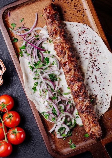 Free photo azerbaijani lule kebab in lavash bread with onion green salad.