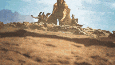 a statue of a man standing on top of a rocky hill with mountains in the background