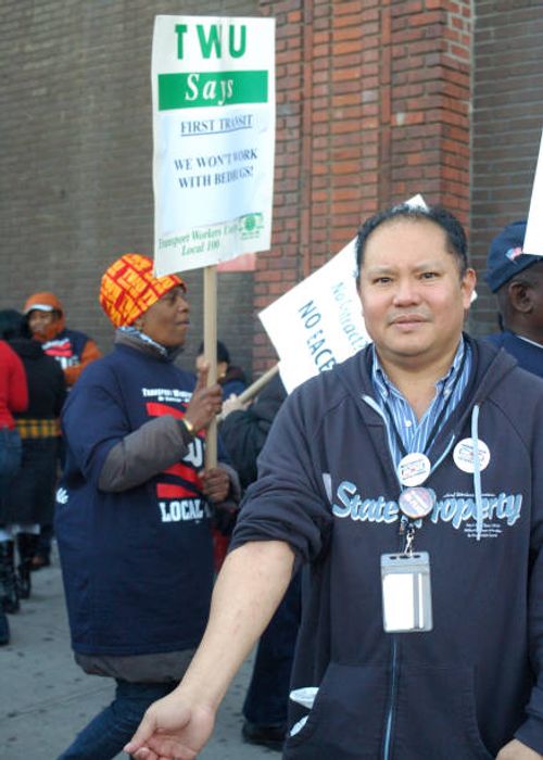 At rally to demand better work conditions, Access-A-Ride customer service rep John Wau shows bedbug bites on his arm, which he says he got from Long...