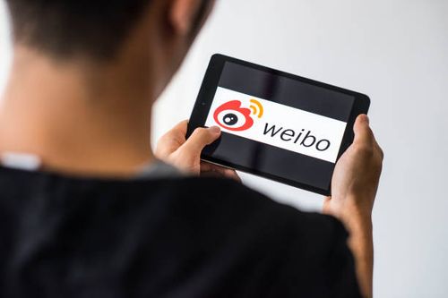 Man holds an Apple iPad Mini as he uses Weibo app on October 4, 2017 in Hong Kong, Hong Kong.