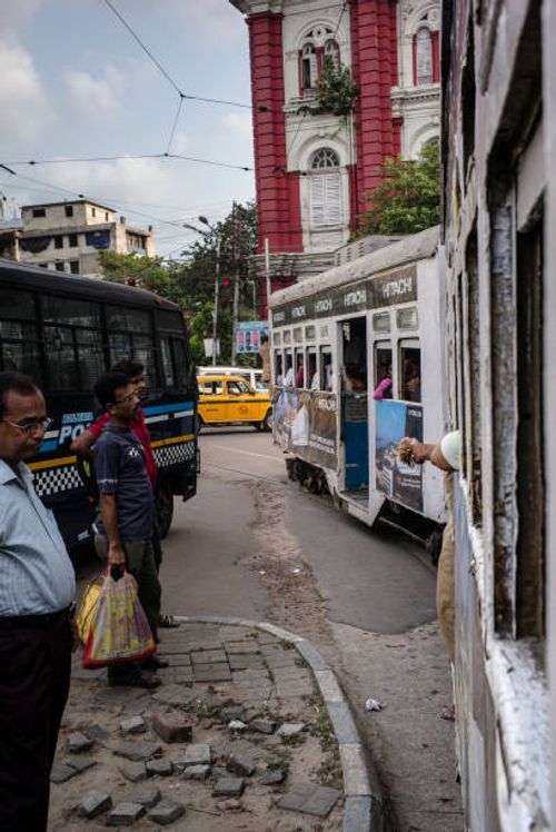 Pedestrians wait as a tram passes by on a street in Kolkata, India, on Friday, May 26, 2017. India is scheduled to release first-quarter gross...