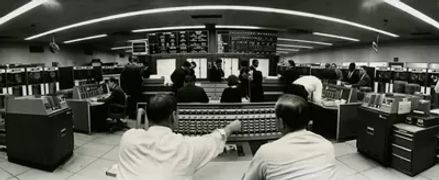 一张戈达德太空中心的黑白照片，画面中布满人员和计算机设备。