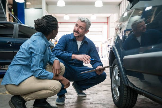 Certified technician reviewing vehicle inspection checklist with customer at Tuttle-Click Tustin Chrysler Jeep Dodge Ram service center in Tustin, CA