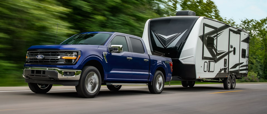 Ford F-150 towing travel trailer on highway demonstrating towing capacity in Southern California