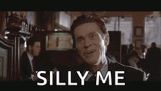 a man in a suit and tie is making a silly face in a restaurant .