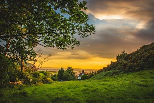 Free A picturesque sunset over the lush, green countryside of Deganwy, Wales, capturing nature's beauty. Stock Photo