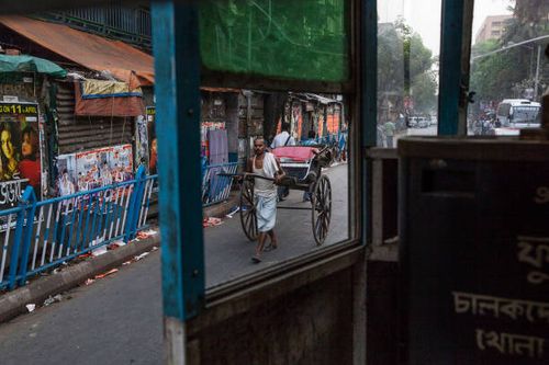 Rickshaw puller seen from a Kolkata tram. Kolkata is perhaps the last place on earth where rickshaws are still pulled on foot. The capital of the...
