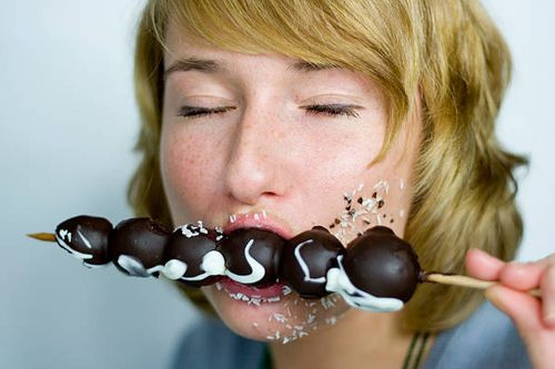 woman eating chocolate fruit spit, closed eyes - chocolate eyes stock pictures, royalty-free photos & images