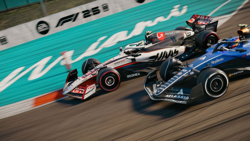 A Haas F1 car races alongside an Alpine F1 car, around the corner of an F1 track.