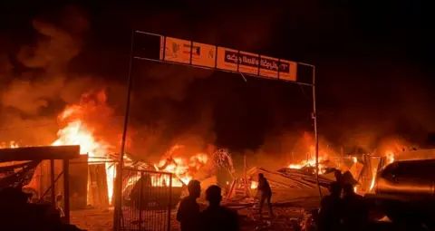 Reuters Fire rages at an area designated for displaced Palestinians in Gaza, 26 May